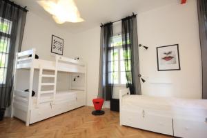 扎达尔The Hostel的卧室配有白色双层床和红色椅子
