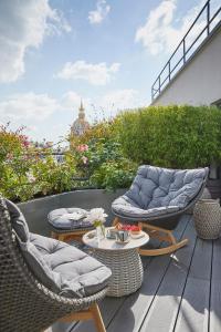 巴黎三科考德旅馆的露台配有两把椅子和一张桌子