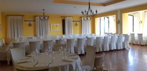 阿尔库阿佩特拉尔卡新德里诗人别墅酒店的一间房间,配有一张桌子和白色的椅子