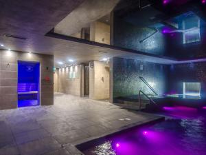 阿贝尔格莱柯玛尔和金斯帕酒店的大型浴室设有紫色灯和热水浴池
