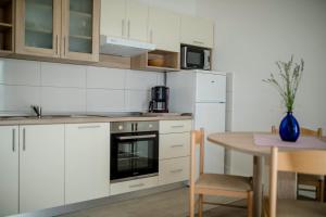 苏佩塔斯卡德拉加Apartments Vidas的厨房配有白色橱柜和桌子