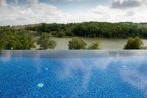 Carla-Bayle劳斯塔尔德尔卡拉特酒店的河畔的大型蓝色游泳池