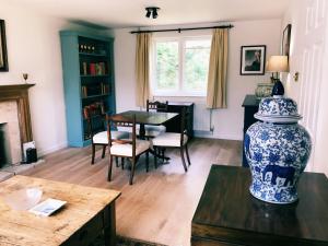 UleyOwlpen Manor Cottages的客厅配有桌子和蓝白花瓶