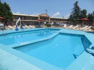 科罗拉多斯普林斯旅行之星套房酒店的一座带椅子的酒店游泳池,一座建筑