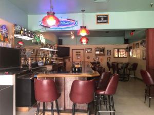 瓦尔迪兹Glacier Hotel的餐厅内带红色酒吧凳的酒吧