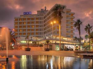 拉克鲁斯H10特内里费海滩酒店的一座棕榈树环绕的大建筑