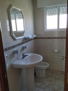 桑亨霍Hotel costa mar的一间带水槽、卫生间和镜子的浴室