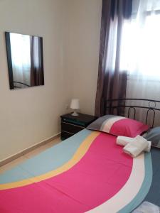 尼亚米卡尼奥纳Jordan's studio house at Nea Michaniona的一间卧室配有一张大床和色彩缤纷的毯子