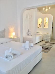 萨索斯Kyano House的一间白色卧室,配有两张床和两面镜子
