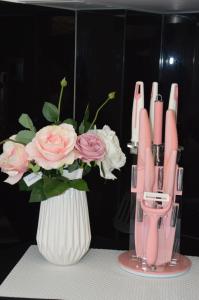 尼亚·卡利克拉提亚S. Luxury Princess Suite的花瓶,有粉红色的笔和一束粉红色的玫瑰花