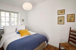 霍恩拜克斯特朗别墅的一间卧室配有一张黄色枕头的床