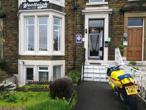 莫克姆维斯特雷酒店的停在房子前面的黄色摩托车