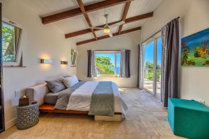 西湾Villa Topaz Above West Bay with 360 Degree Views!的一间卧室配有一张床、一张沙发和窗户。