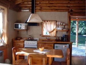 圣卡洛斯-德巴里洛切恩尔科拉宗德尔博斯克山林小屋的厨房配有木桌和炉灶。