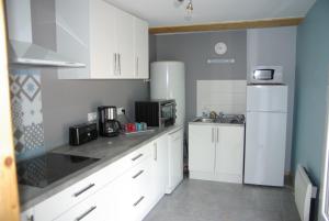 VendeuvreGRANGE du BOSQUET的厨房配有白色橱柜和白色冰箱。