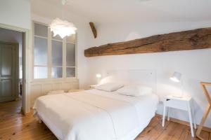 LanciéGite le Pot de Vin的卧室设有白色的床和木制天花板。