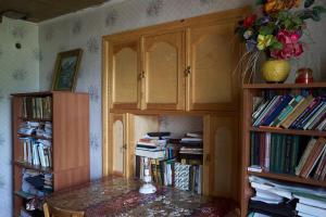 LahıcAncient Lahij Guest House的一间设有桌子和书架的房间