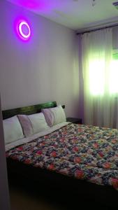 非斯LES CHRIFIs ETAPE AÉROPORT NAVETTE AÉROPORT GRATUITE的卧室配有一张床铺,墙上有紫色的光线