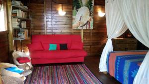 黑角Insolite Arawakane Gîtes du Manial的客厅配有红色沙发和地毯。