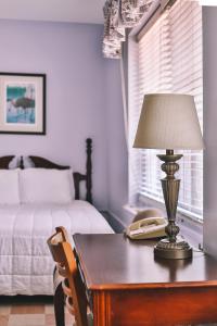 克劳福德维尔The Lodge at Wakulla Springs的一间卧室配有一张桌子、一盏灯和一张床