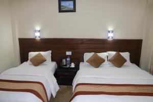 索拉哈奇特旺乡村度假酒店的配有2张床铺的酒店客房,配有白色床单和棕色枕头