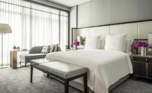 吉隆坡吉隆坡四季酒店的卧室配有一张白色大床和一把椅子
