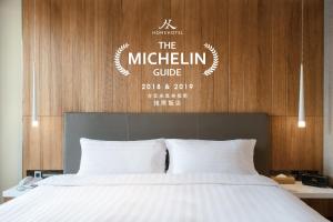 台北Home Hotel 的一张配有白色床单的床。
