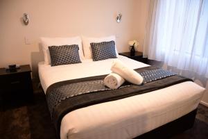 特卡波湖Tekapo Luxury Apartments的卧室配有一张带白色床单和枕头的大床。