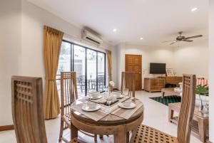 南芭堤雅AnB poolvilla 2BR with private beach in pratamnak的用餐室以及带桌椅的起居室。