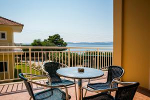 拉瑟拉西酒店的海景阳台上配有一张桌子和四把椅子