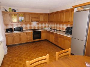 Videm pri PtujuHaus Videm的厨房配有木制橱柜、桌子和冰箱。