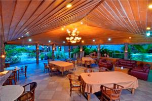圣吉吉太平洋海滩别墅酒店的一间带桌椅和吊灯的餐厅