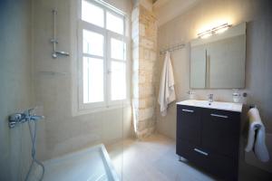 罗希姆诺Novecento Studios的一间带水槽和镜子的浴室以及窗户。