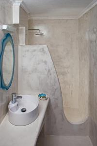 佩里萨Roula Villa Studios & Apartments的白色的浴室设有水槽和镜子