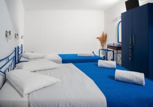 佩里萨Roula Villa Studios & Apartments的蓝色和白色的客房内的三张床