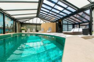 布鲁日Boutique Hotel Die Swaene的一座带玻璃天花板的别墅内的游泳池