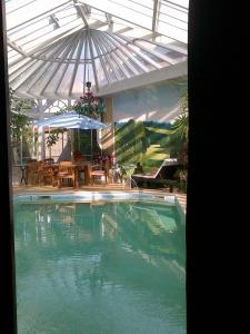 布尔日圣博内剧院酒店的一个带遮阳伞和庭院的大型游泳池