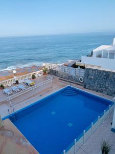 圣地亚哥港Casa al Mar的毗邻大海的大型蓝色游泳池