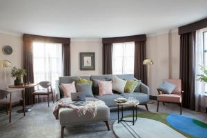 都柏林亚历克斯酒店的客厅配有蓝色的沙发和椅子