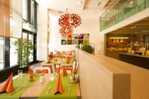维也纳宜必思维也纳会展中心酒店的一间设有长桌的餐厅,上面有橙色锥形
