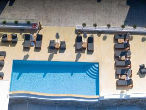 普拉迪斯亚罗斯Seethrough Mykonos Suites的享有带躺椅的游泳池和游泳池的顶部景致