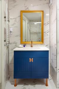 伊斯坦布尔Güner Business Hotel的浴室设有蓝色梳妆台和镜子