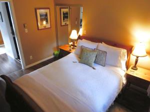 惠斯勒贝勒纳齐套房：惠斯勒的一间卧室配有一张带两盏灯的大型白色床。