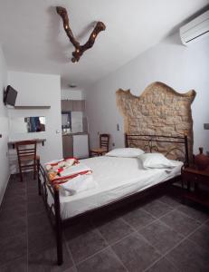 乔拉弗雷恩多斯Margarita's Rooms的一间卧室设有一张大床和石墙