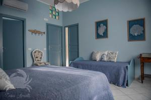 圣温琴佐Casa Amati - Sea house apartments的蓝色卧室配有两张床和椅子