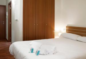 索尔德乌Andorra4days Soldeu - El Tarter的卧室配有白色床和毛巾