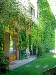 佛罗伦萨勒翠斯坦兹酒店的一座被绿色常春藤覆盖的建筑,在院子里设有桌子