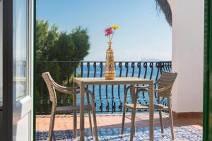 蒙德罗Villa Mallandrino的阳台配有带花瓶的桌椅