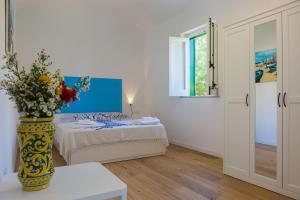蒙德罗Villa Mallandrino的一间房间,里面设有一张床和一个花瓶
