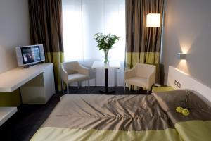 鲁瑟拉勒Parkhotel Roeselare的一间医院房间,配有床和两把椅子以及一台电视